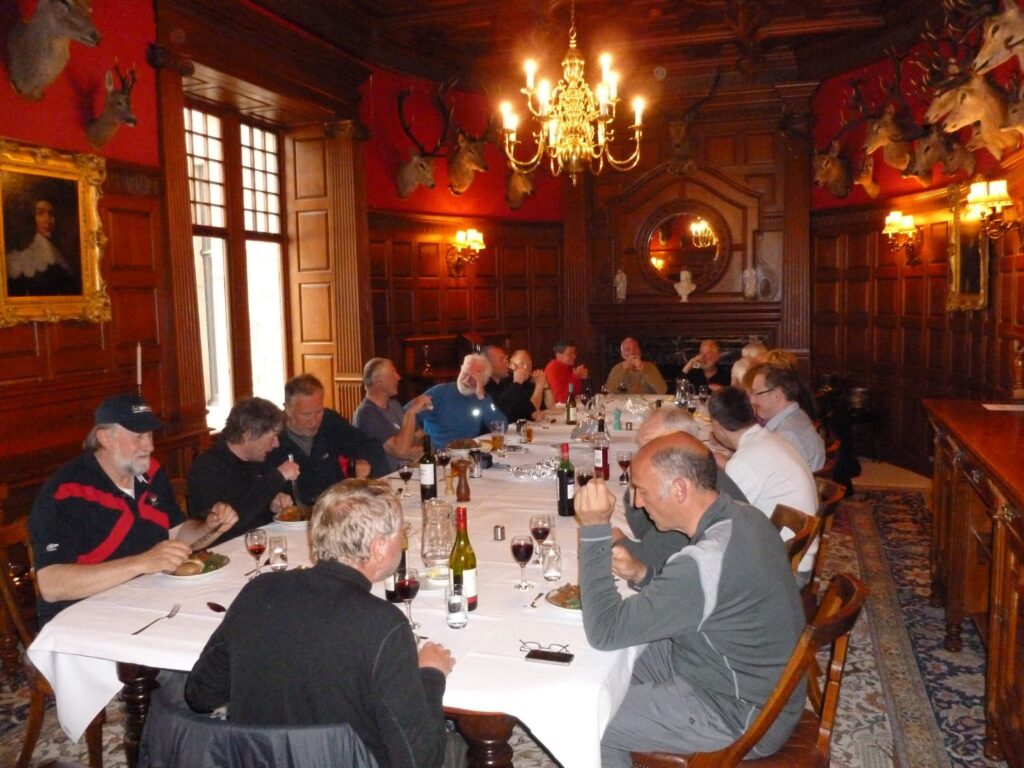 Challengers at a long dining table in luxurious pannelled room at Mar Lodge