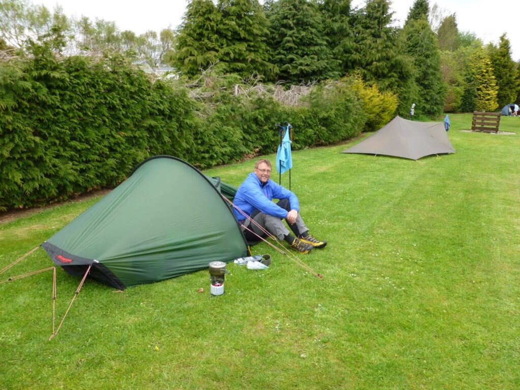 A smiling David sitting by his tent at the Feughside camp site.