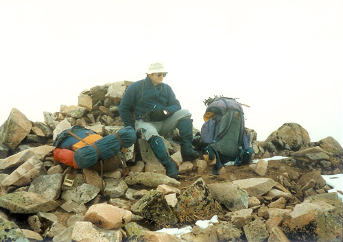 Mike sitting on the summit cairn at the top of Carn Mor Dearg