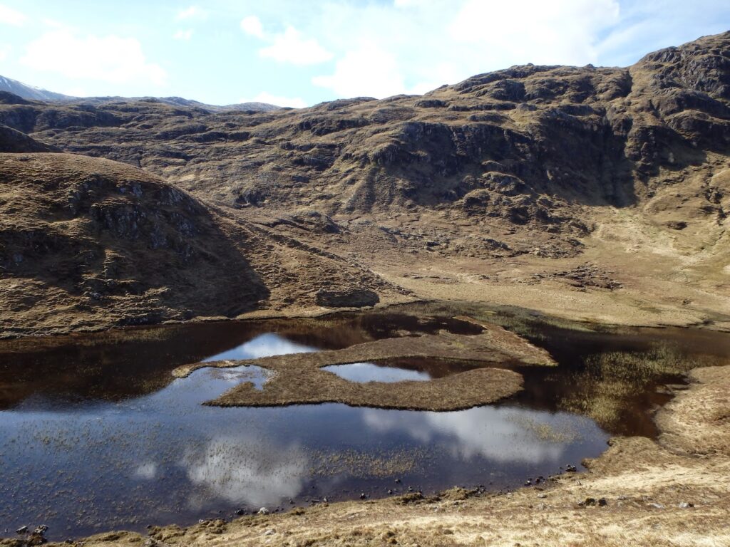 Small lochan surrounded by rocky hills
