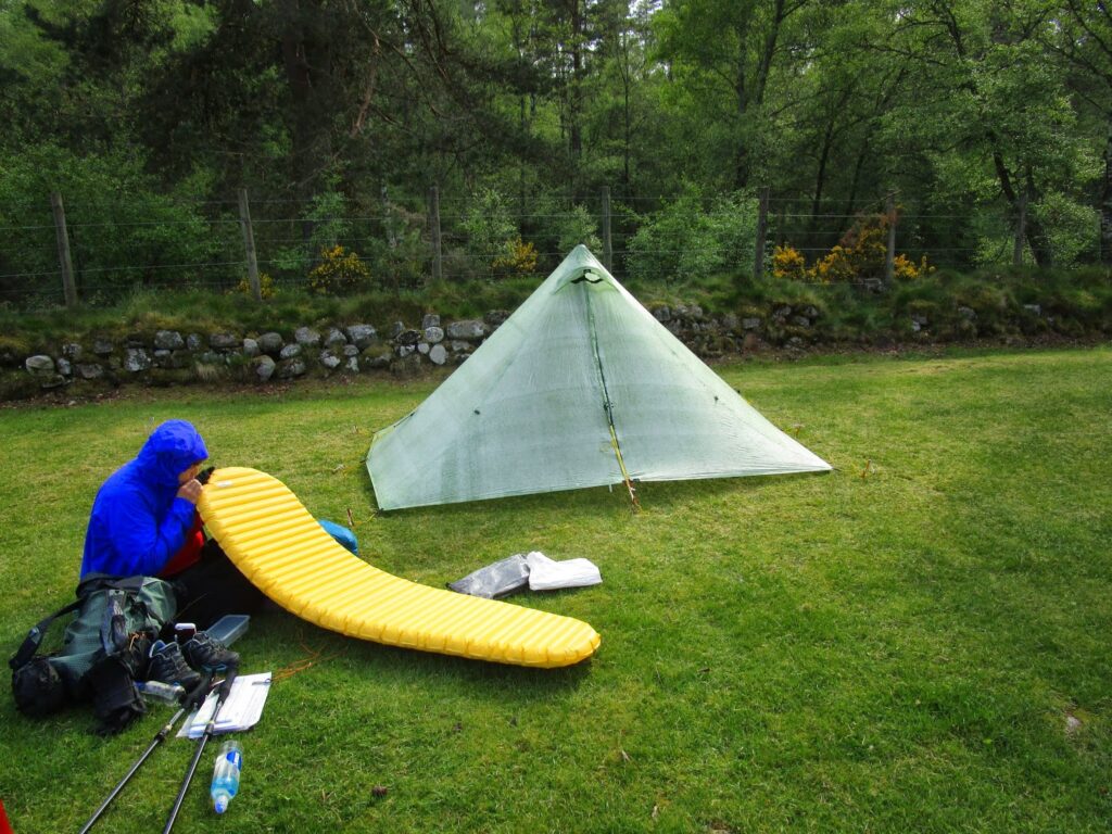 Vicky inflates her sleep mattress outside the Duomid tent