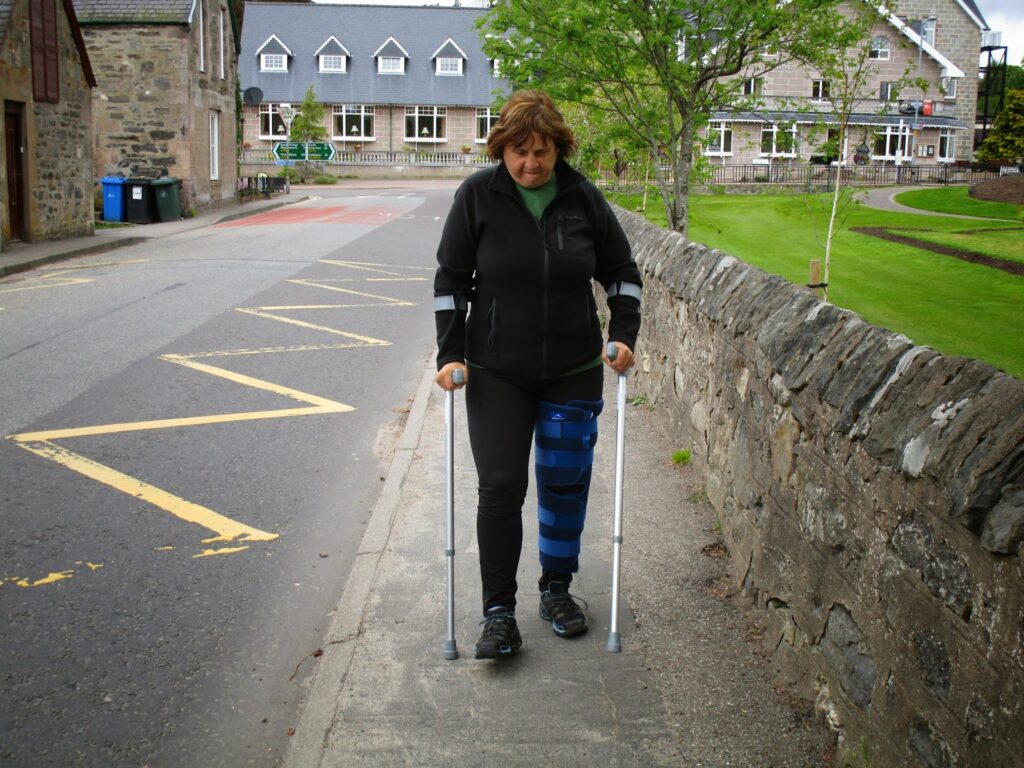 Vicky on crutches, making her way for the 3 blocks from the Tipsy Laird Bunkhouse to the Kingussie train station