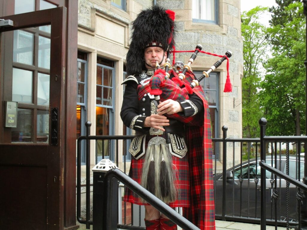 A piper plays the bagpipes outside the hotel