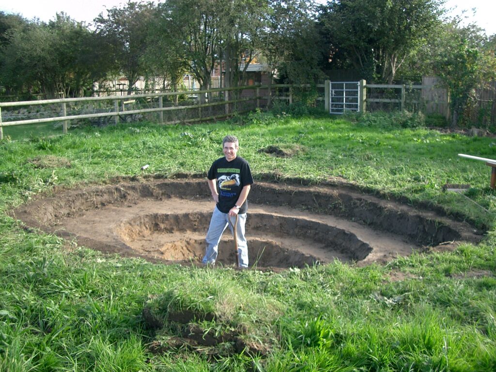 Phil excavating pond showing plant terraces.